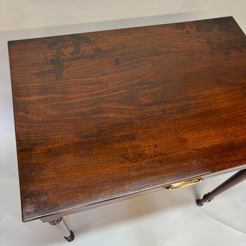 A George III mahogany side table featuring a single drawer with an oval brass handle and slender turned legs. View IV