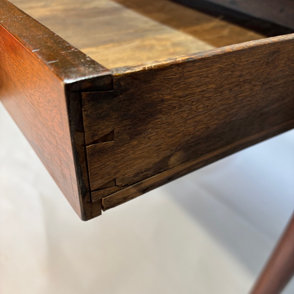 A George III mahogany side table featuring a single drawer with an oval brass handle and slender turned legs. View V
