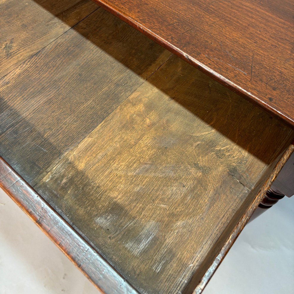 A George III mahogany side table featuring a single drawer with an oval brass handle and slender turned legs. View VI
