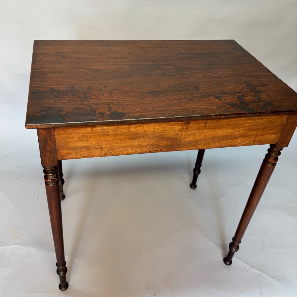 A George III mahogany side table featuring a single drawer with an oval brass handle and slender turned legs. View VIII