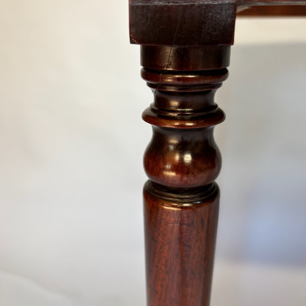 A George III mahogany side table featuring a single drawer with an oval brass handle and slender turned legs. View IX