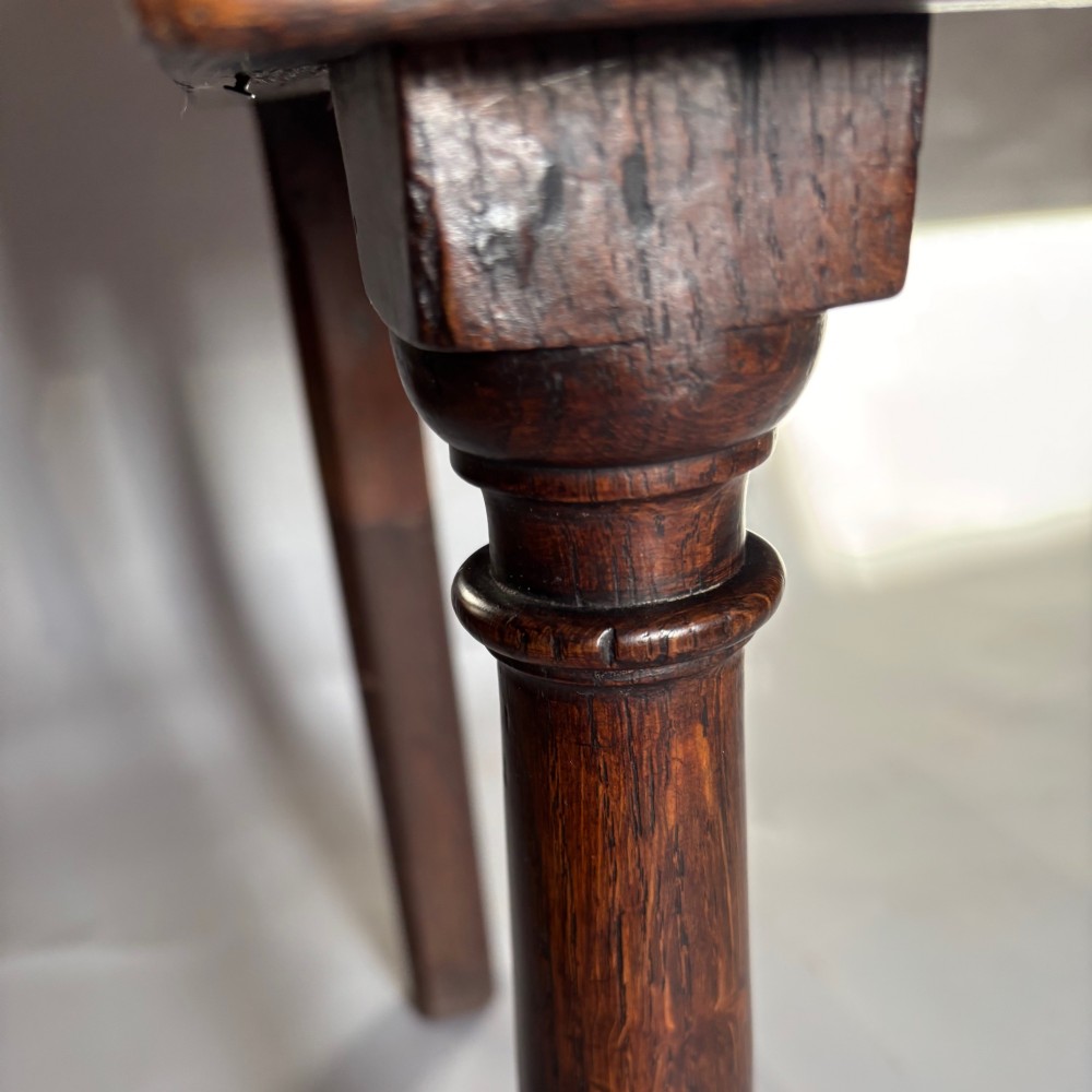 A late 17th-century dark oak low dresser featuring geometric moulded drawer fronts, brass teardrop handles, and turned front legs. View XIII