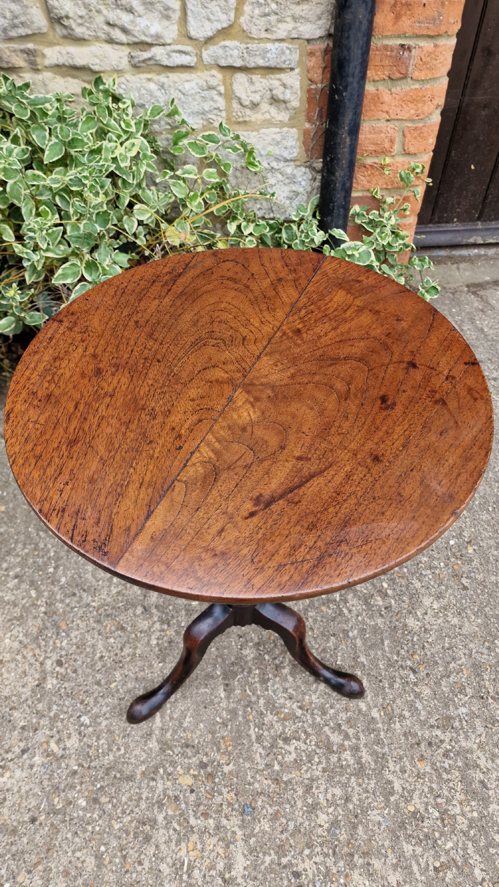 A Georgian fruitwood tilt top wine table with a circular top, turned central column, and tripod cabriole legs on pad feet. View II