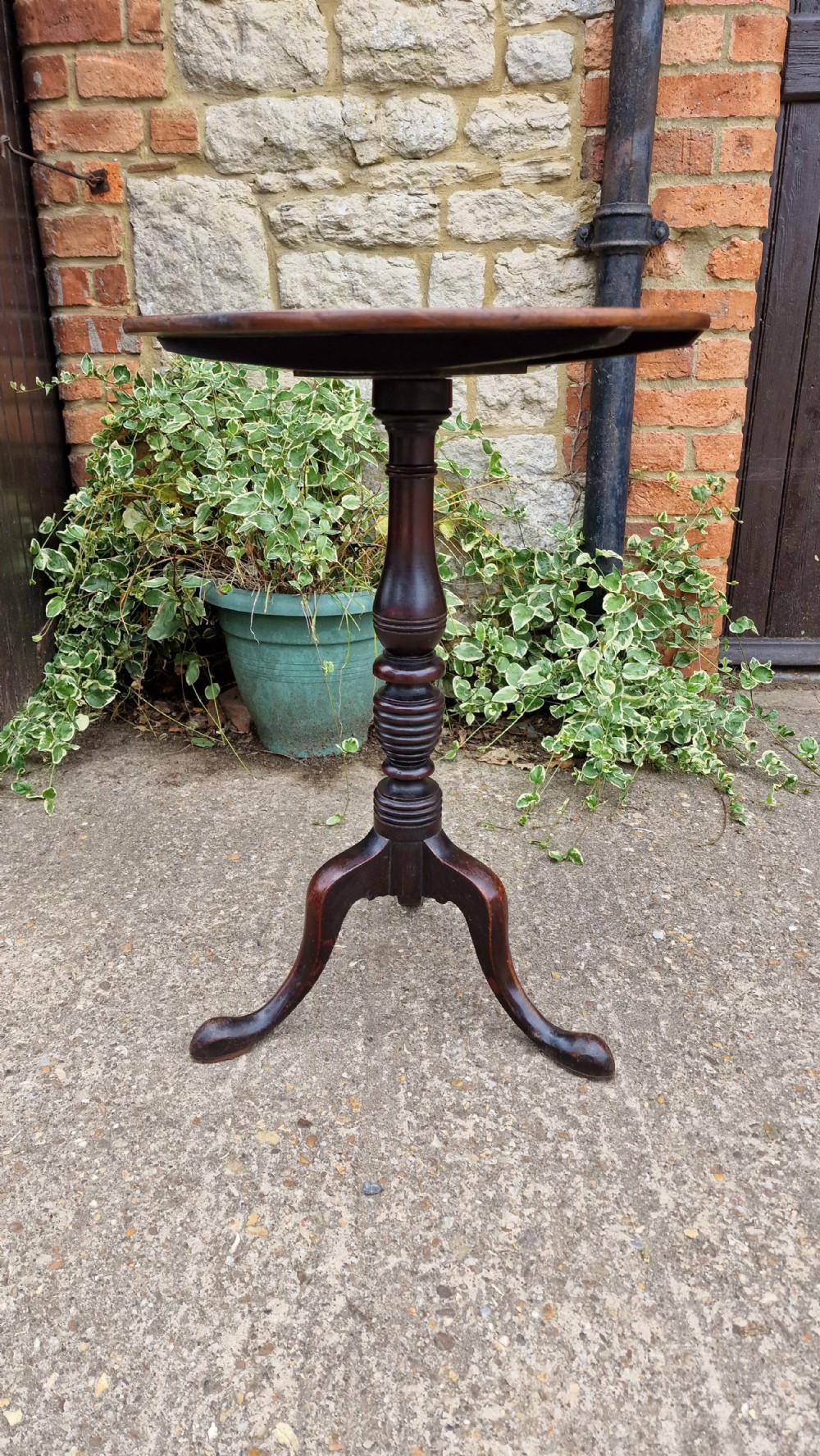 A Georgian fruitwood tilt top wine table with a circular top, turned central column, and tripod cabriole legs on pad feet. View III