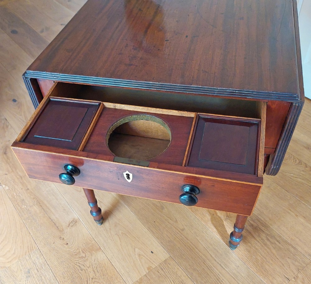 A Regency mahogany Pembroke table featuring drop flaps, a drawer with turned wood knobs, and reeded turned legs on brass castors. View VIII