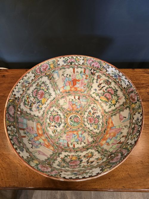 fig 1. A large deep porcelain punch bowl decorated with hand-painted Chinese Famille Rose enamel motifs, featuring figures, flora, birds, and butterflies within reserves.