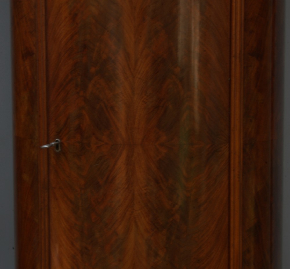 A pair of tall 19th-century Danish Biedermeier mahogany oval pedestal cabinets with flame veneers, moulded tops, and single fitted doors. View VIII