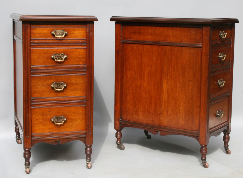A pair of late Victorian mahogany four-drawer bedside chests featuring brass handles, fluted sides, and turned legs on castors.