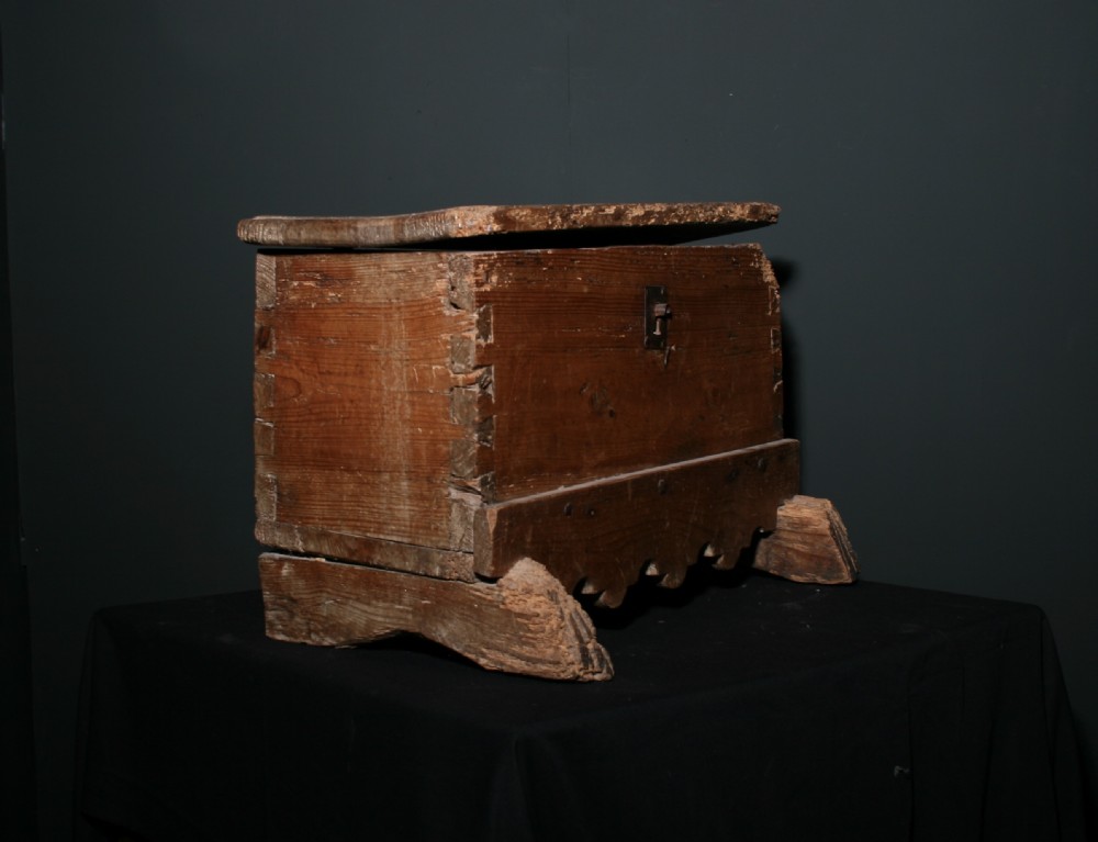 A rustic pine chest featuring exposed dovetail joints, a central iron keyhole plate, a scalloped lower apron, and carved wooden feet. View III