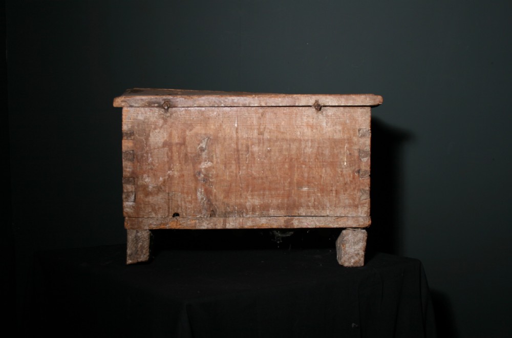 A rustic pine chest featuring exposed dovetail joints, a central iron keyhole plate, a scalloped lower apron, and carved wooden feet. View IV