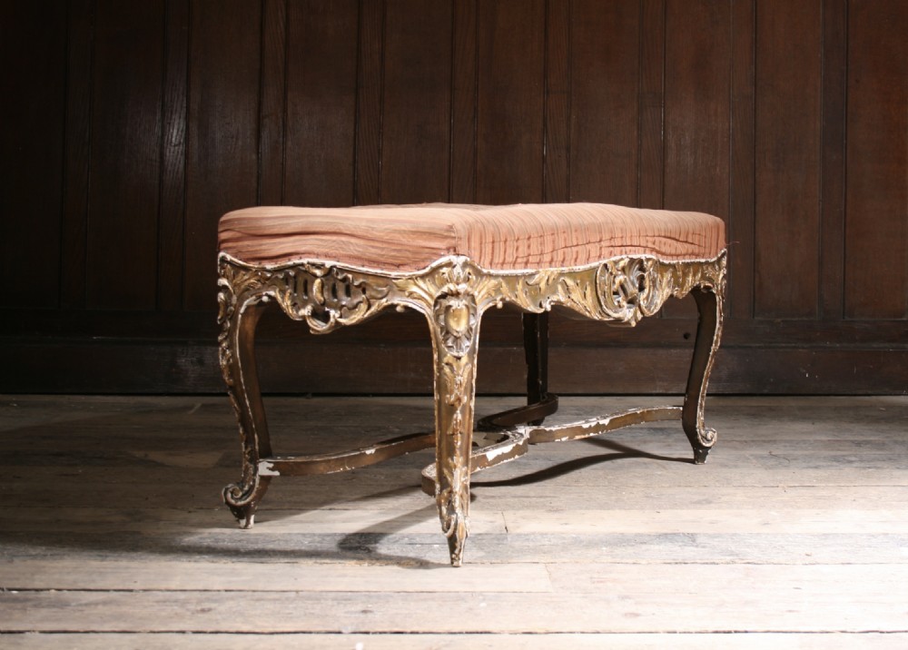 An early 19th-century rectangular low stool featuring a carved giltwood frame with cabriole legs and a striped fabric seat. View II