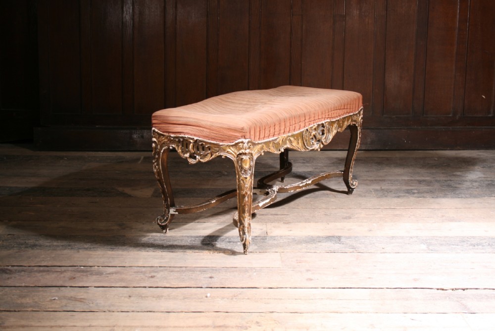 An early 19th-century rectangular low stool featuring a carved giltwood frame with cabriole legs and a striped fabric seat. View III