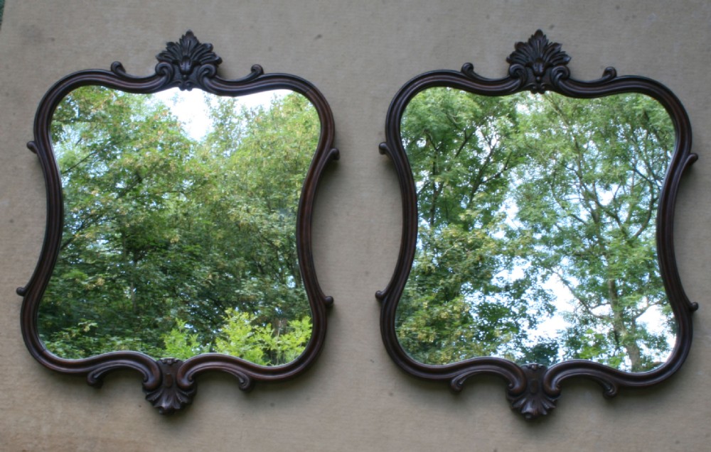 A matching pair of mid-Victorian dark rosewood wall mirrors with shaped serpentine frames and carved acanthus crests. View III