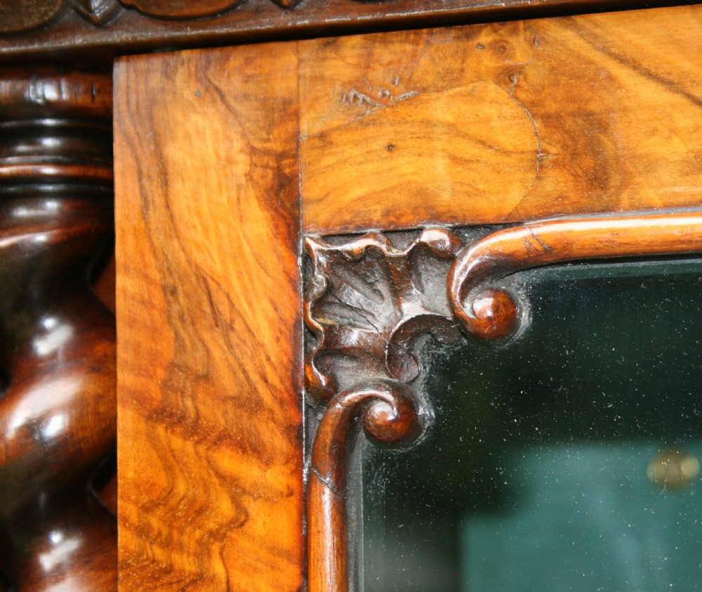 A large two-tier Victorian glazed bookcase crafted in figured walnut with spiral barley twist columns and carved mouldings. View V