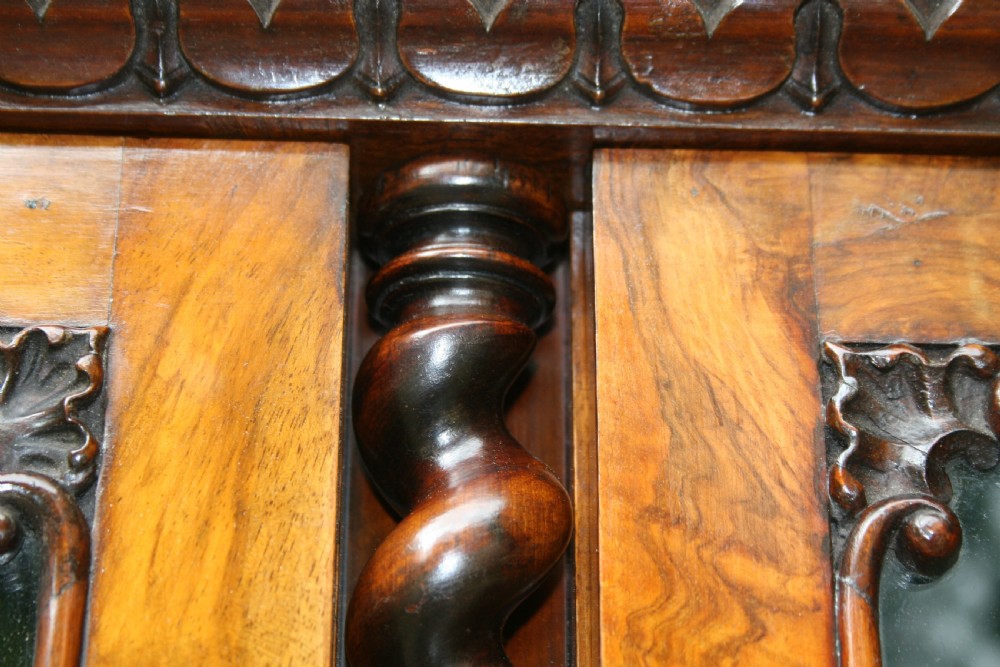 A large two-tier Victorian glazed bookcase crafted in figured walnut with spiral barley twist columns and carved mouldings. View VIII