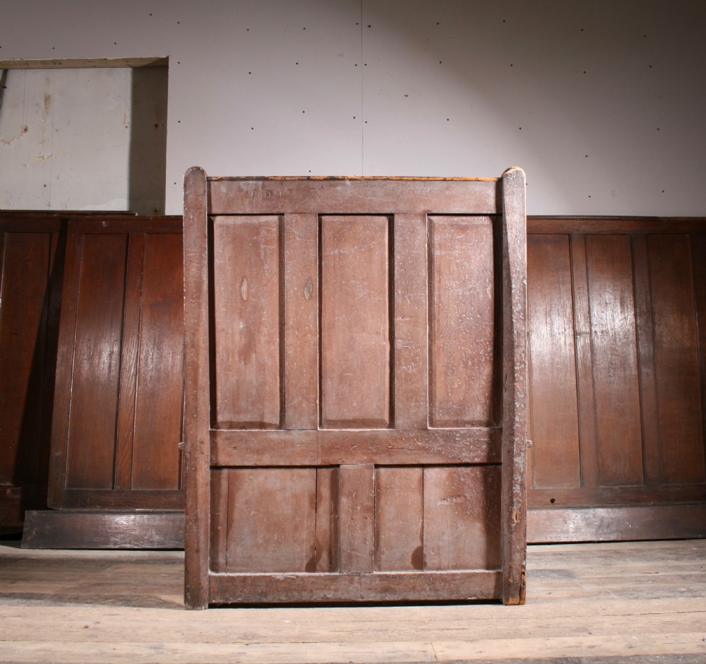 A dark brown Georgian pine settle with a high panelled back, straight wooden armrests, and two drawers set into the base. View IV