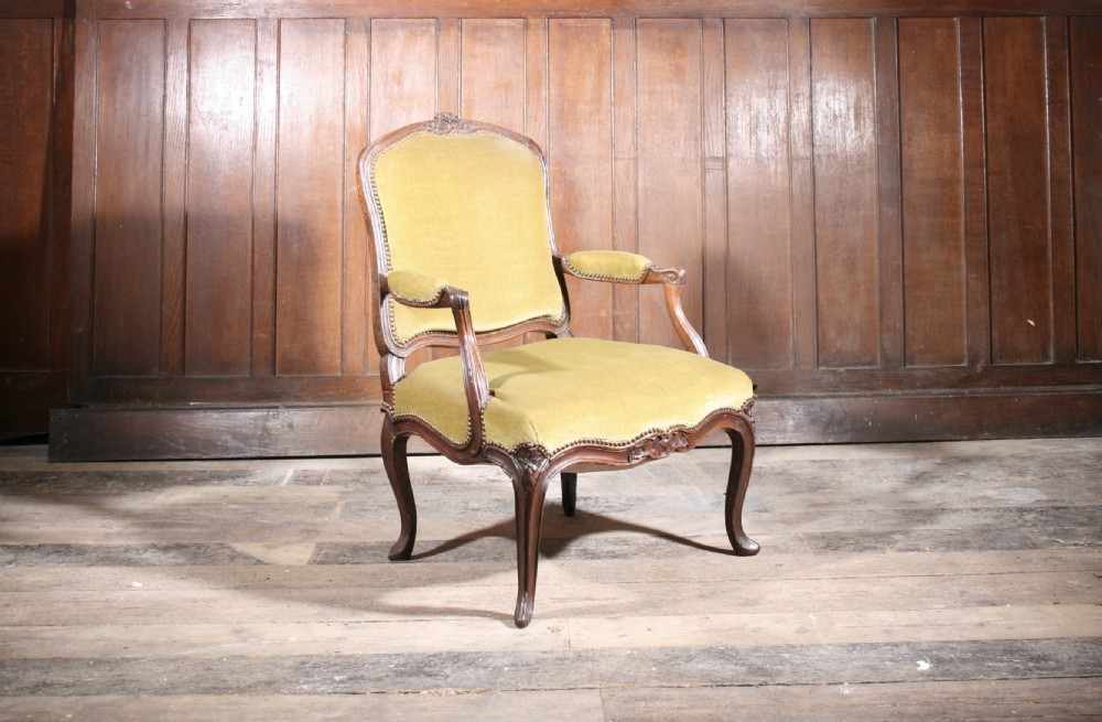 An 18th-century carved walnut armchair with olive green upholstery and cabriole legs. View II