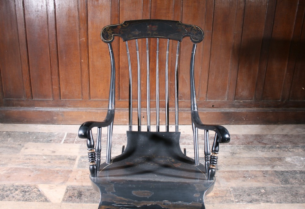 A Swedish painted wood rocking chair with a spindle back, curved armrests, turned legs, and a black distressed finish. View VII