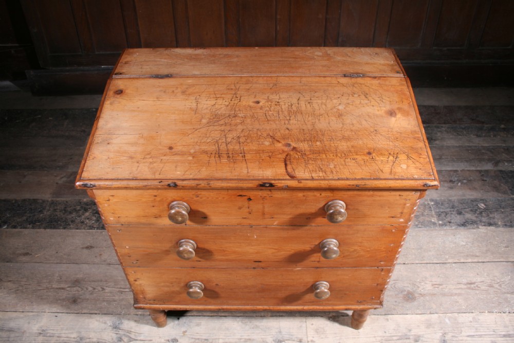 A Georgian pine mule chest featuring a hinged top lid, three lower drawer fronts with turned wooden knobs, and turned legs. View III
