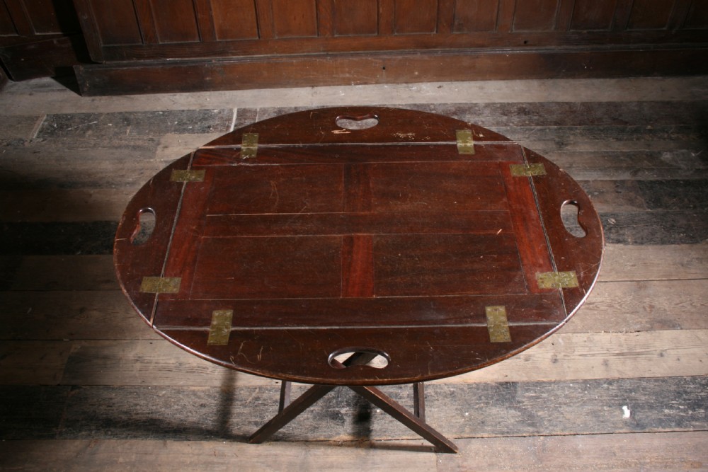 A dark mahogany Georgian butler tray with folding sides and brass hinges resting atop a matching wooden X-frame folding stand. View V