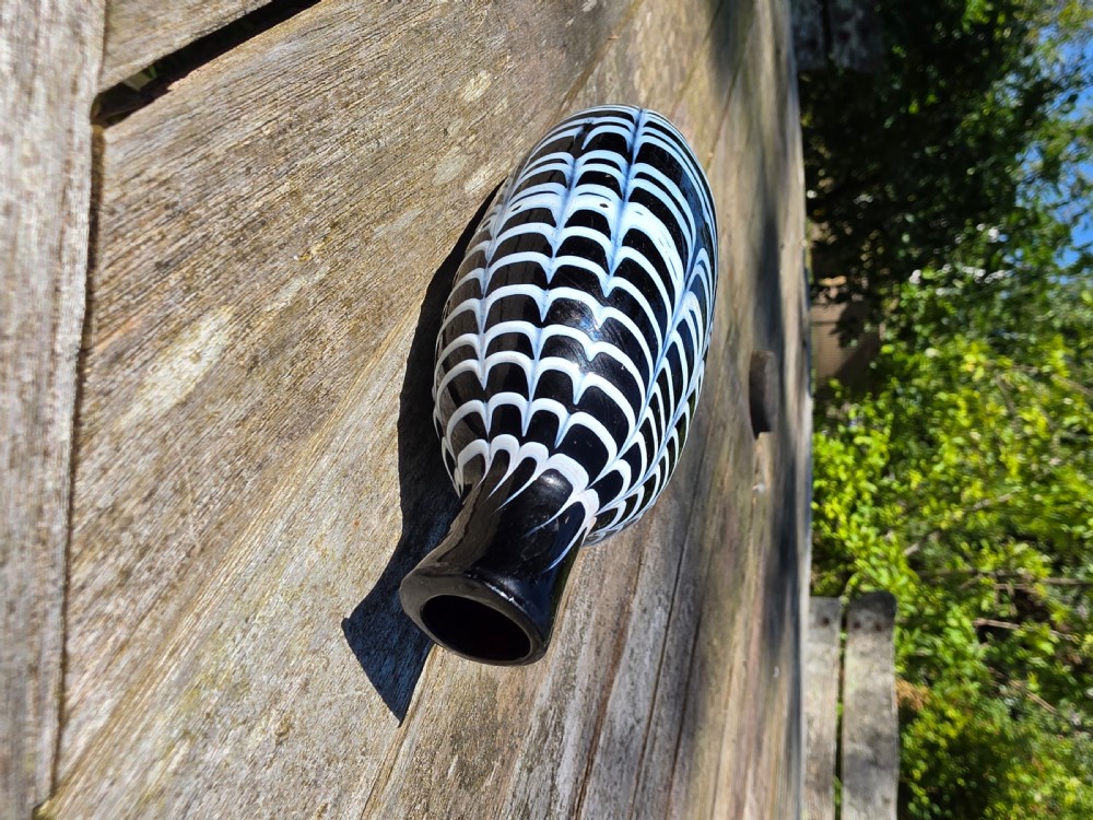 A Georgian dark glass pocket flask featuring white combed festoon trailing and a narrow neck. View VII