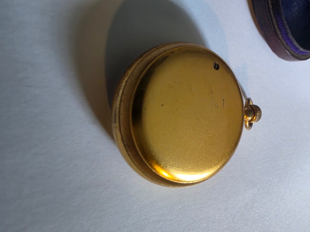A circular Victorian brass pocket barometer with a silvered dial and altitude scale alongside its open plush-lined leather case. View V