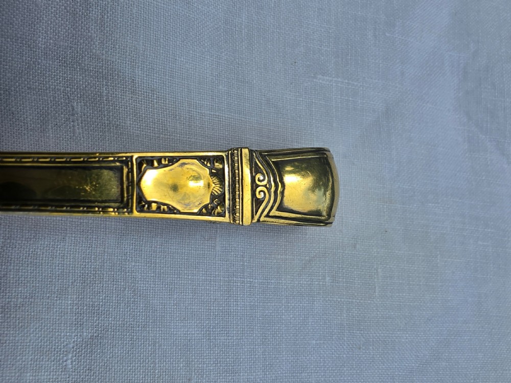A gold silver-gilt pastry server featuring perforated spade-shaped blades and an ornamented handle. View VII
