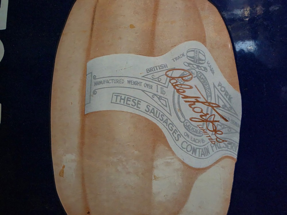 A tall vertical cobalt blue vitreous enamel sign featuring white block lettering for Palethorpes sausages and a pictorial central graphic. View II