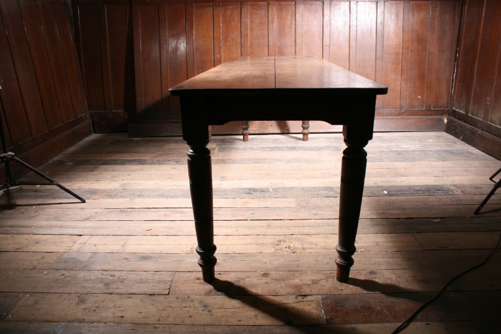 A long antique poplar farmhouse dining table featuring a twin-plank top supported by four turned wooden legs. View II