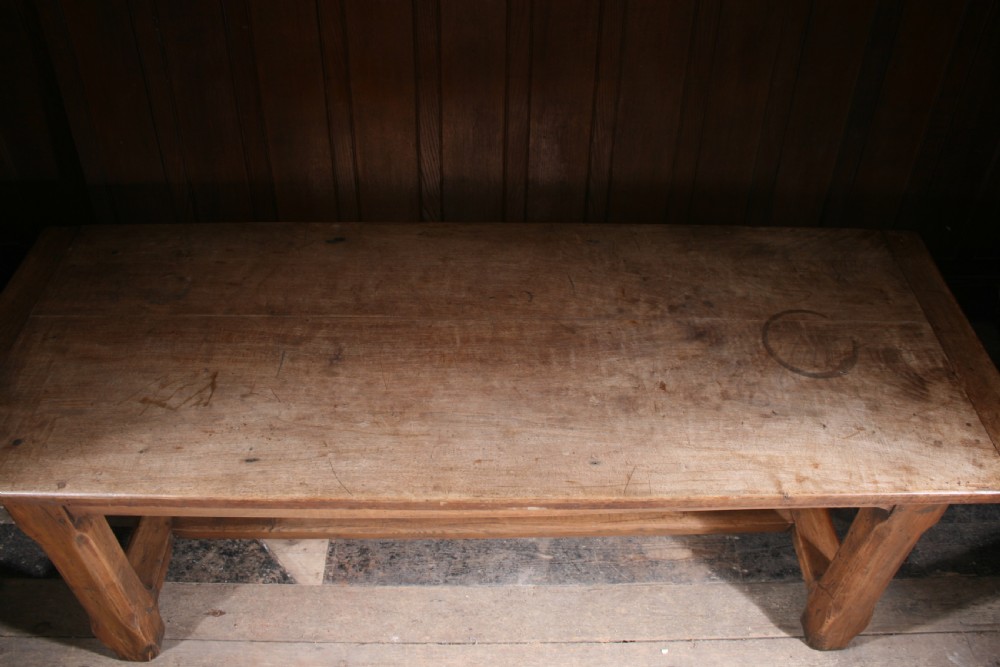 An antique walnut farmhouse dining table featuring a twin plank timber top, a single end drawer with a metal ring pull handle, and heavy legs connected by a central stretcher. View VII
