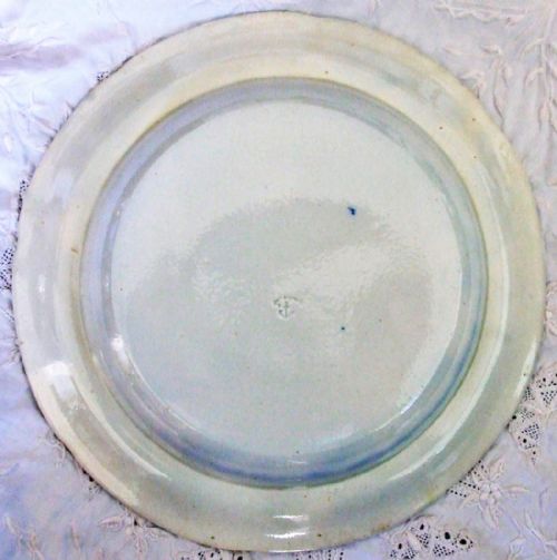fig 1. A circular Georgian blue and white earthenware plate featuring an underglaze transfer print of a rural cottage scene surrounded by a wide floral border.