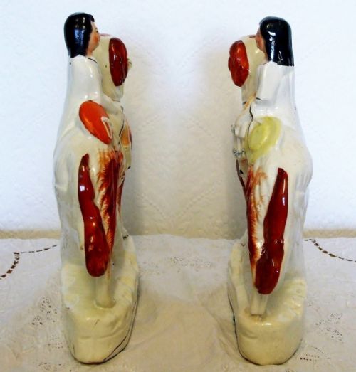 fig 1. A facing pair of Victorian Staffordshire earthenware figures depicting children riding rust and white setter dogs carrying baskets of flowers.