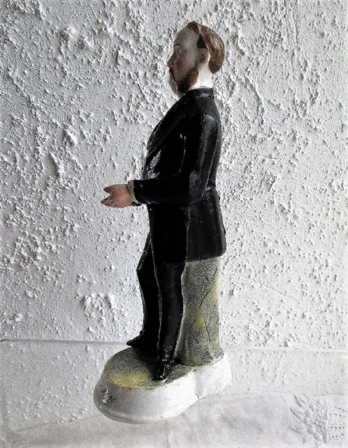 fig 1. A standing Victorian porcelain figurine of a man wearing a black frock coat with outstretched hands, mounted on a round base inscribed with Mr Sankey.