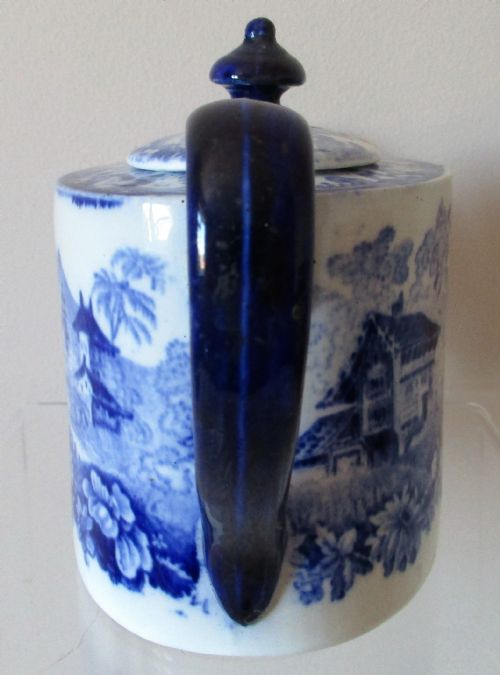 fig 1. A Victorian Mintons solitaire porcelain teapot displaying a blue and white Genevese transferware landscape pattern with a cobalt blue handle, spout, and finial.