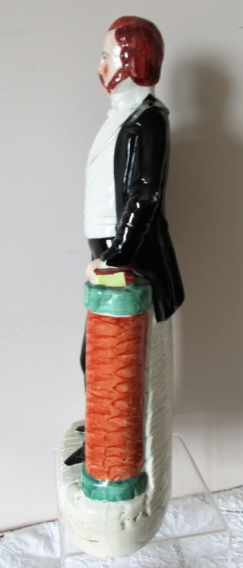 fig 1. An antique Victorian Staffordshire earthenware portrait figure depicting Ira Sankey standing in a black suit beside a red column with the name Sankey on the base.