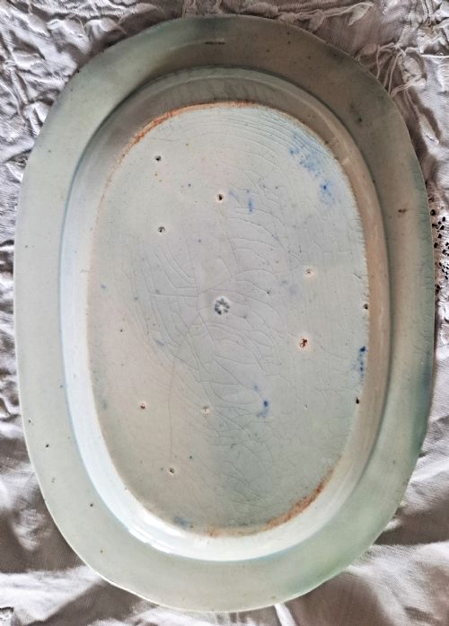 fig 1. An oval Georgian earthenware serving dish featuring a cobalt blue transferware pattern of classical ruins and surrounding landscape.