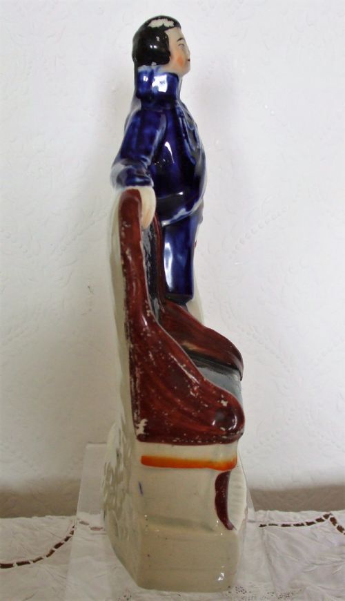 fig 1. An antique Victorian Staffordshire earthenware portrait figure depicting the Prince of Wales in a cobalt blue jacket standing beside a chair on an inscribed white base.