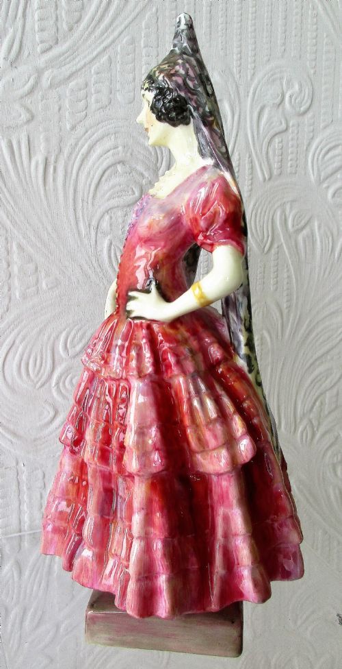 fig 1. A Royal Doulton glazed porcelain figurine depicting a lady in a red tiered dress and black mantilla.