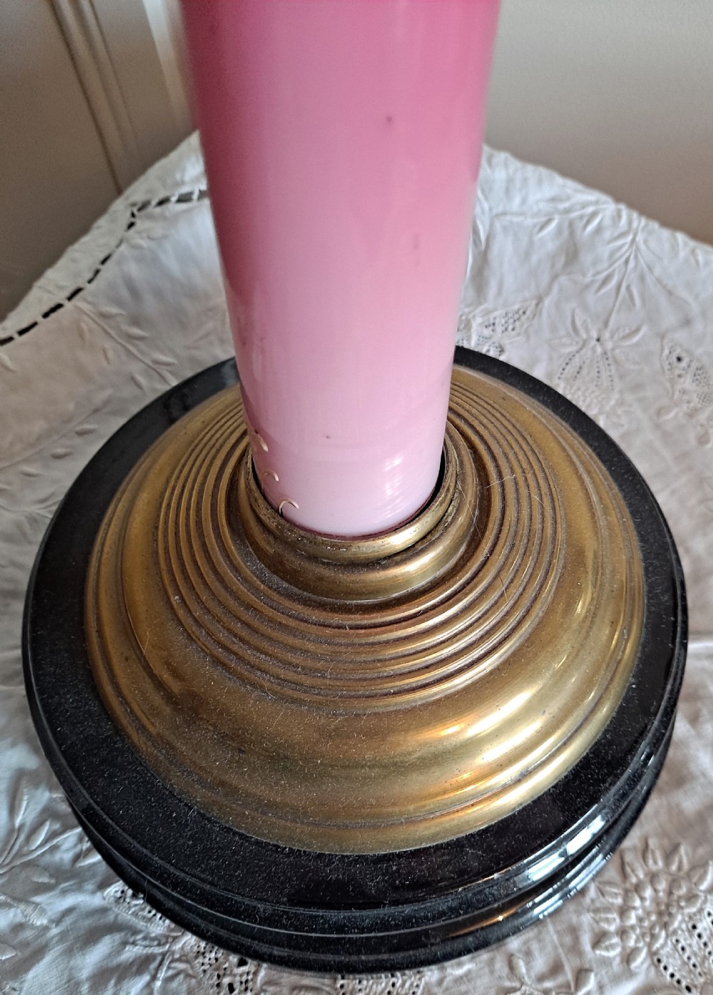 A Victorian column oil lamp featuring a cranberry pink etched glass shade, a matching pink glass reservoir, and a brass column on a black circular base. View VI