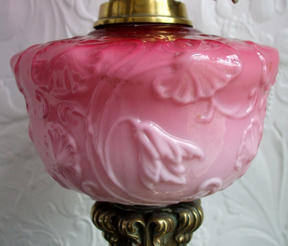 A Victorian oil lamp with a cast brass scrolled base, a pink moulded glass font, and a cranberry frilled glass shade. View III