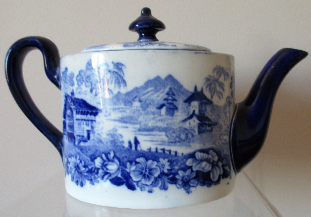 A Victorian Mintons solitaire porcelain teapot displaying a blue and white Genevese transferware landscape pattern with a cobalt blue handle, spout, and finial. View III