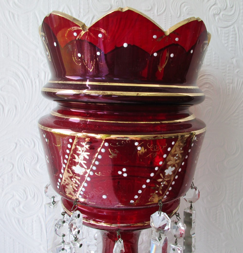 A pair of deep ruby red glass Victorian lustres featuring scalloped upper rims, hand-painted gold foliage, and suspended clear cut-crystal prisms. View IV