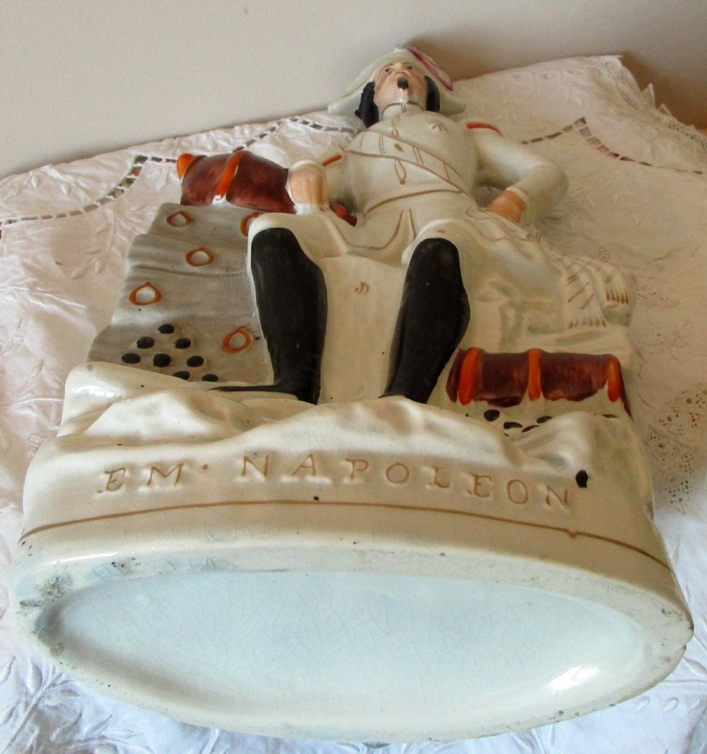 An antique Victorian Staffordshire earthenware portrait figure depicting Emperor Napoleon III in uniform seated beside a cannon. View V