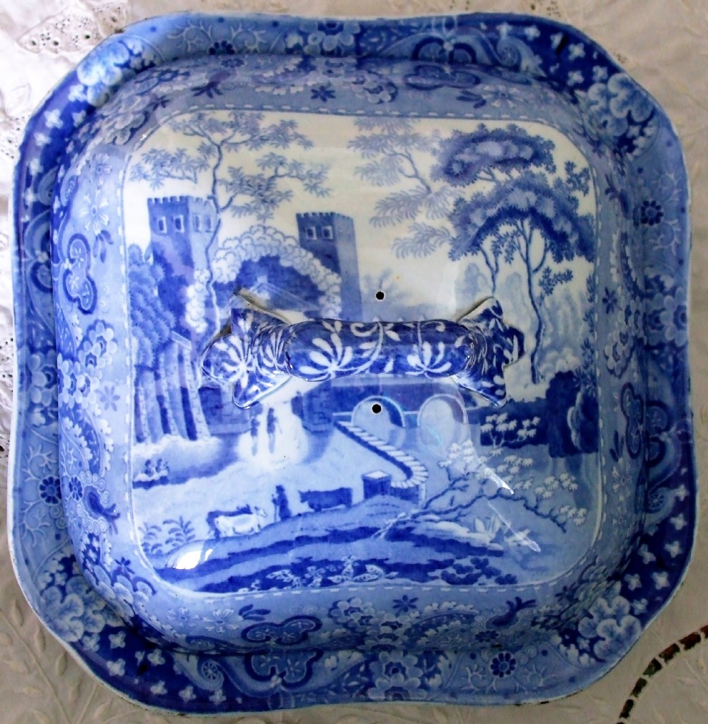 A square Georgian blue and white transferware pottery vegetable tureen cover depicting a castle landscape pattern with a central moulded handle.