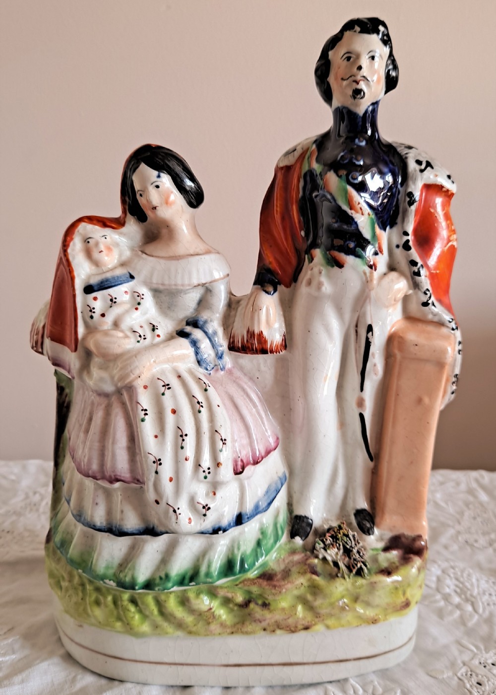 A Victorian Staffordshire earthenware flatback figure group depicting Emperor Napoleon III, Empress Eugenie, and the infant Prince Imperial with hand-painted enamel details.