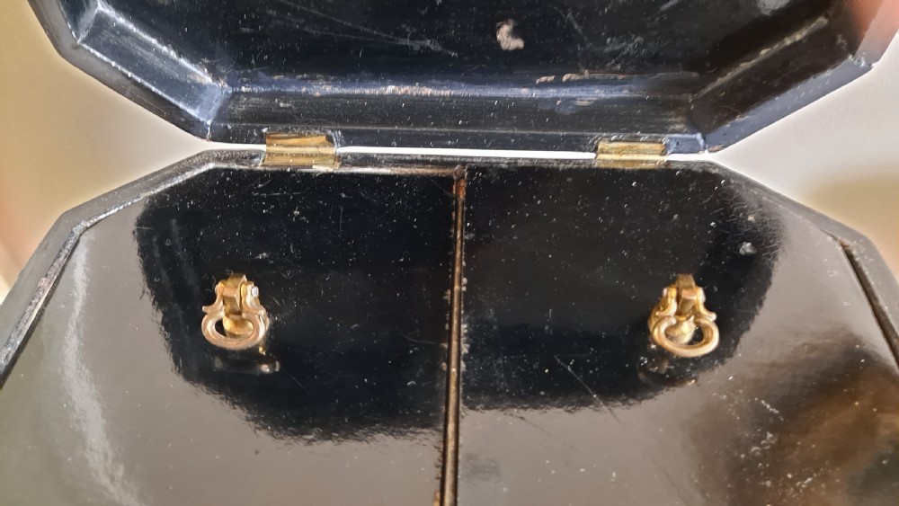 A black Victorian papier-mache tea caddy featuring mother-of-pearl floral inlays and gold painted embellishments on a shaped pedestal base. View VIII