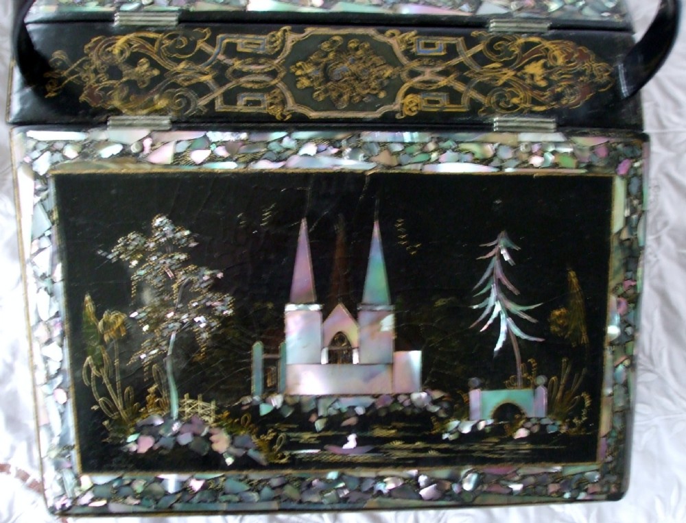 A Victorian black lacquered papier-mache needlework casket featuring mother-of-pearl inlay, gilded foliate patterns, and an overhead carrying handle. View III