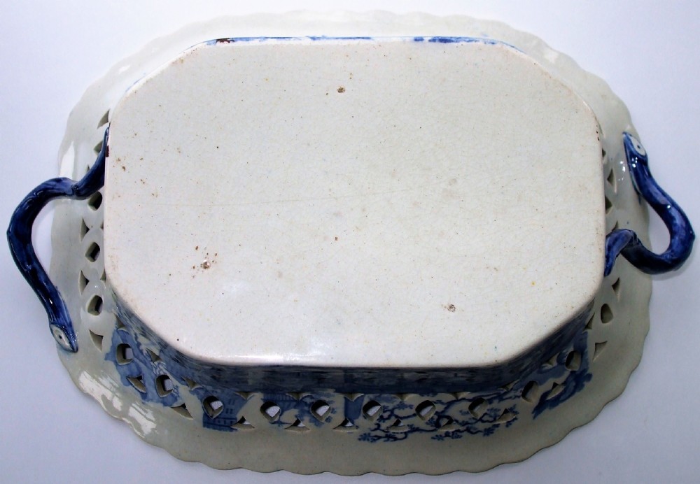 An antique oval blue and white earthenware chestnut basket featuring pierced openwork sides and a central printed river landscape scene. View VIII