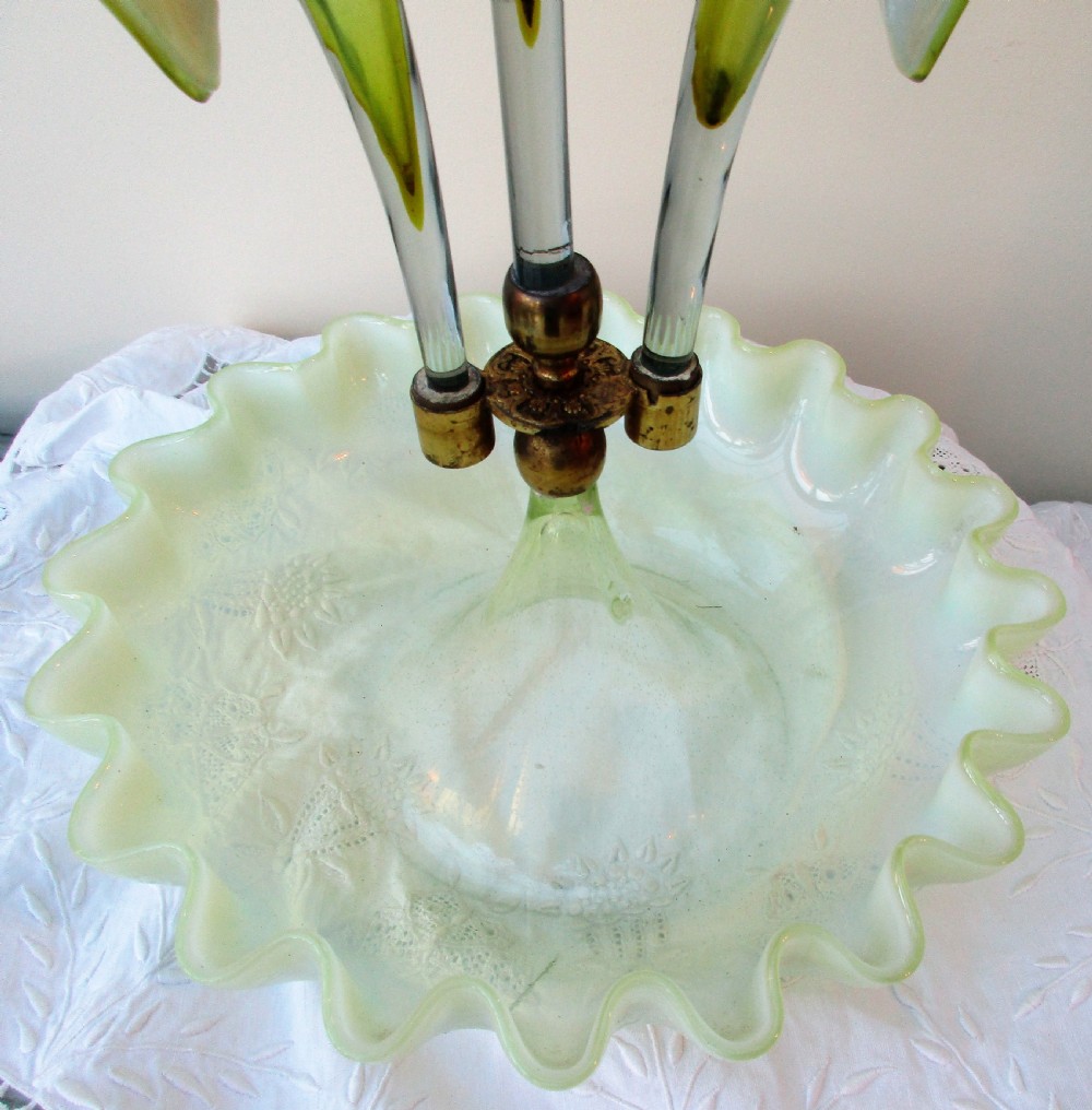 A Victorian Art Nouveau translucent green glass epergne featuring a ruffled base bowl and two fluted lily-form glass trumpets joined by a metal collar. View VI