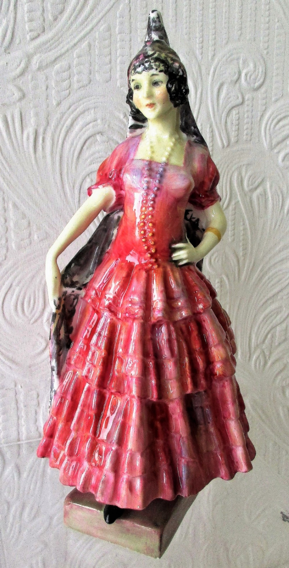 A Royal Doulton glazed porcelain figurine depicting a lady in a red tiered dress and black mantilla.
